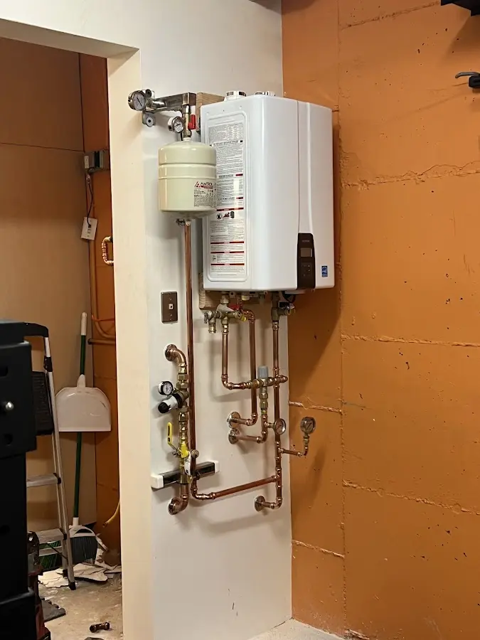 Plumbing technician inspecting water heater connections in Richardson